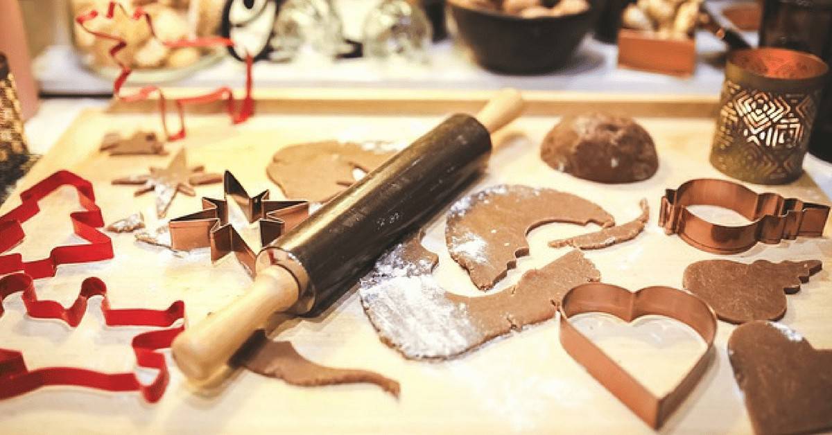 cookies shown cut out with cookie cutters on the counter with a rolling pin.