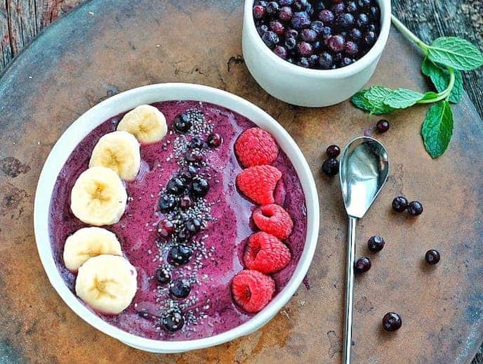 a smoothie bowl with raspberries and blueberries