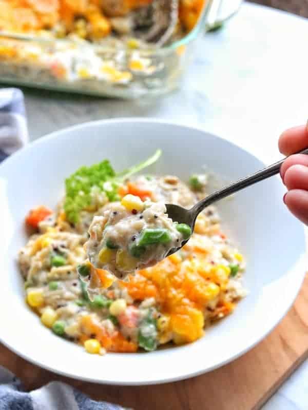 Turkey Casserole in a white bowl with a spoon showing a close up of the baked casserole. 