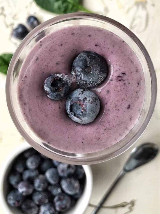 blueberry smoothie with frozen blueberries on top