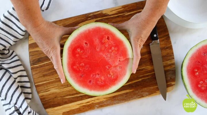 Watermelon cut in half on cutting board