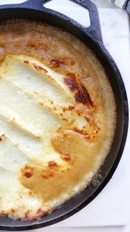 Crustless chicken pot pie shown straight from the oven in a black cast iron pan.