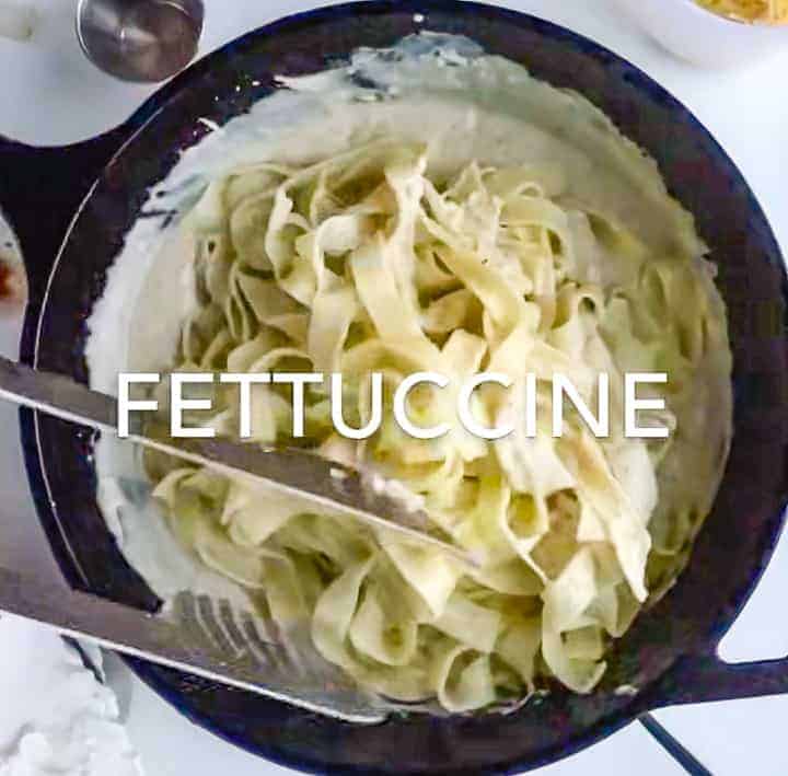  fettuccine noodles being added to the sauté pan with the Greek yogurt sauce.