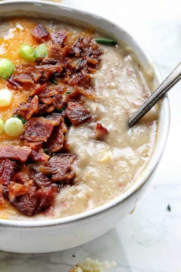 a close up of bacon on top of potato soup in a bowl