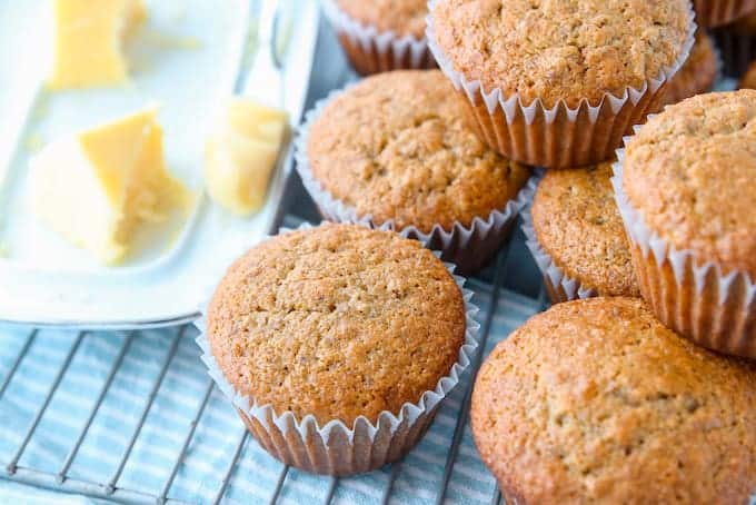 Healthy Bran Muffins, the best bran muffin recipe showing muffins stacked on a wire rack with a butter dish next to them.
