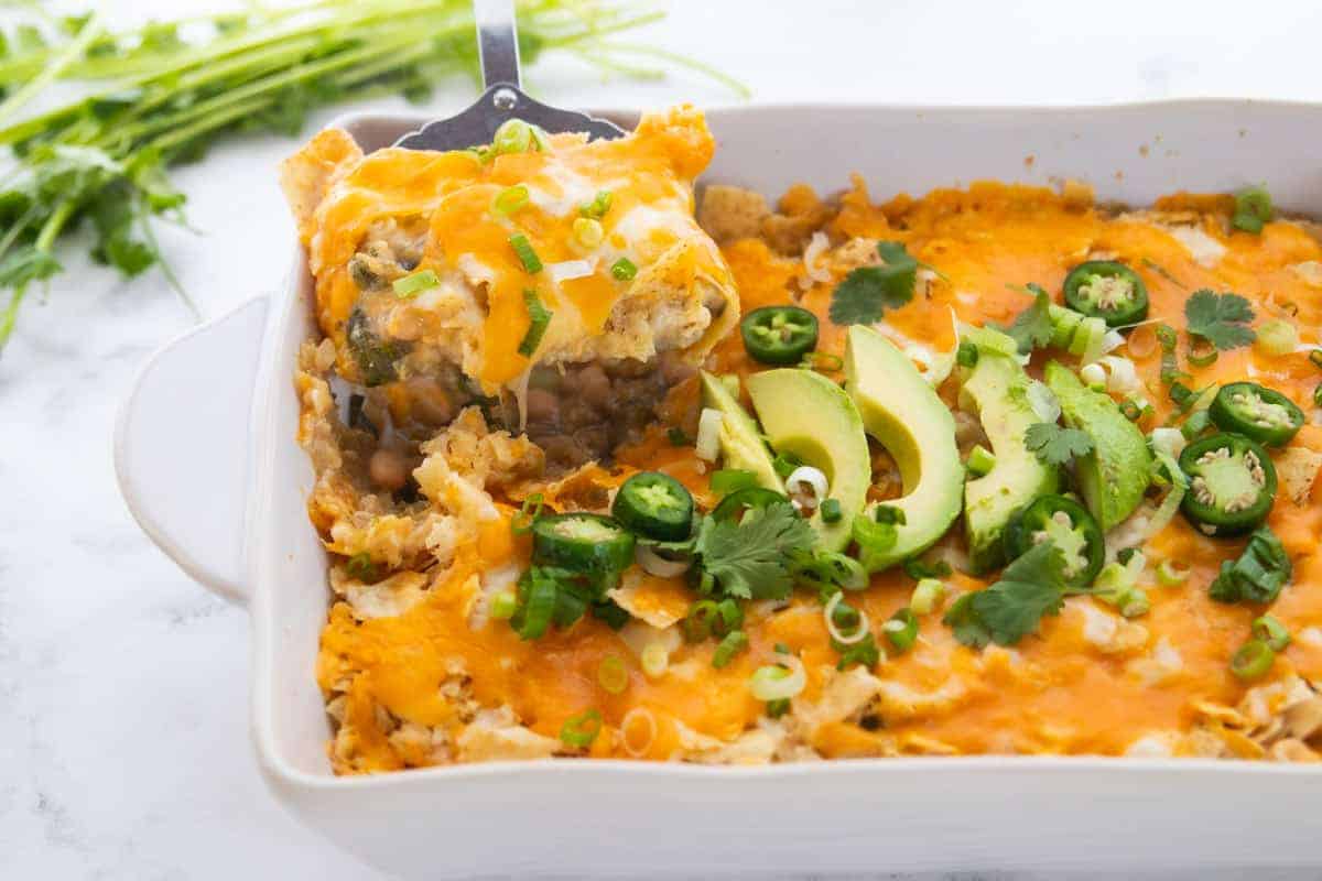 Chicken Tortilla Chip Casserole showing a spatula scooping a serving of casserole from the baking dish.