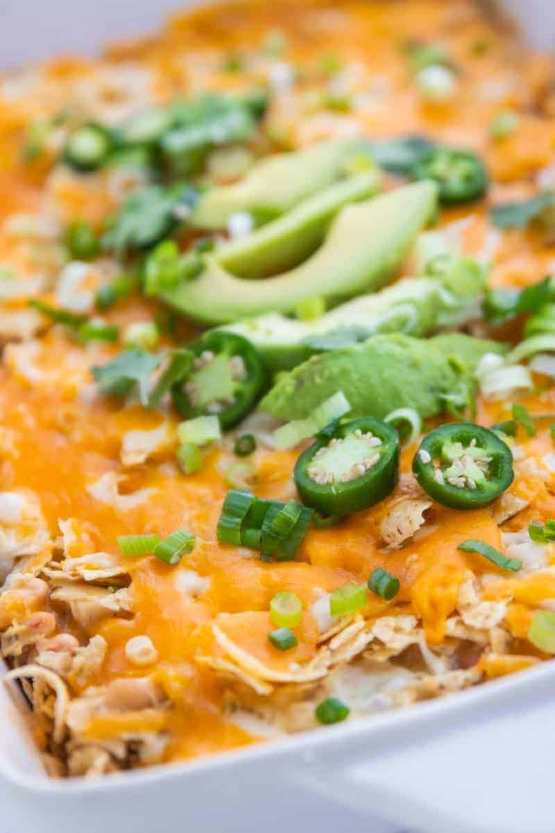 Chicken Tortilla Chip Casserole showing the casserole topped with jalapenos, avocado and green onions