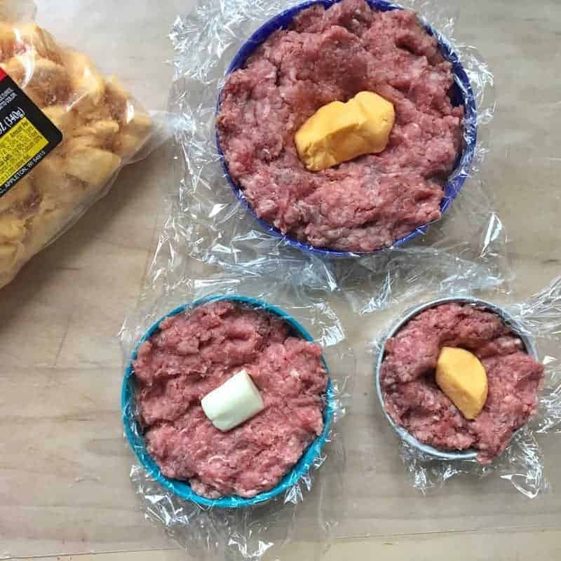 Ground beef in a lid with Syrian wrap and a cheese curd - making cheese stuffed burgers