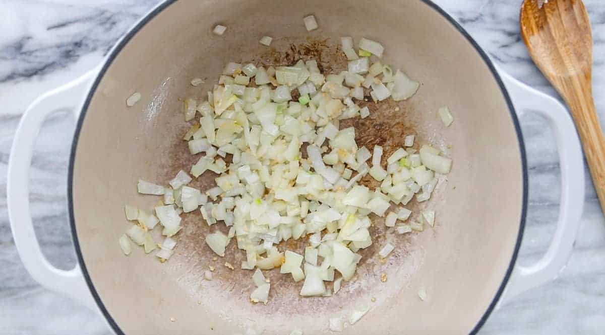 onions being sauteed in a stock pot.