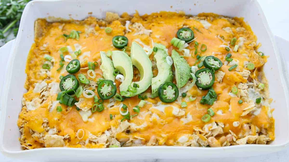 Chicken Tortilla Chip Casserole showing toppings on top of the baked casserole.