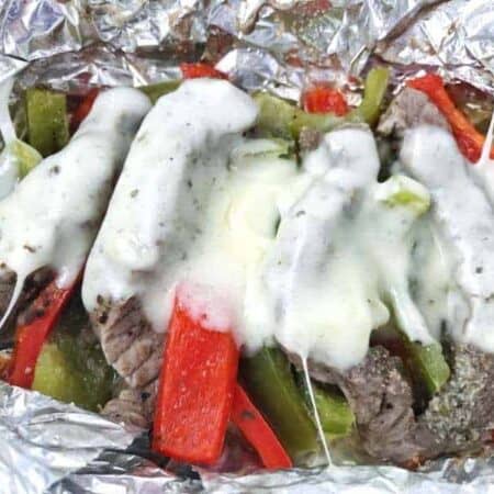 Cheese melted on top of steak and peppers