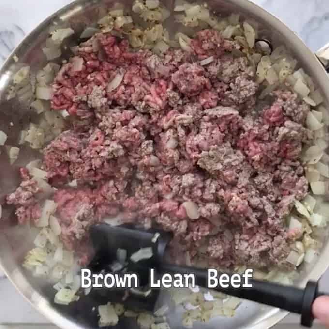 Beef is being browned with onions in a skillet.