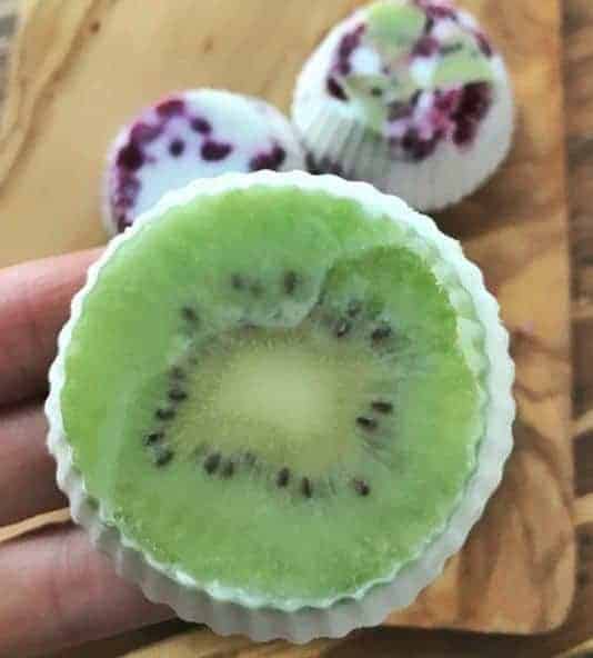 A kiwi slice frozen into a yogurt bite shown up close.