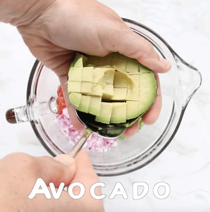 a hand removing avocado from the shell