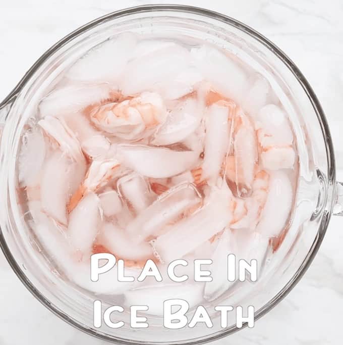 Parboiled shrimp in an ice bath in a clear bowl