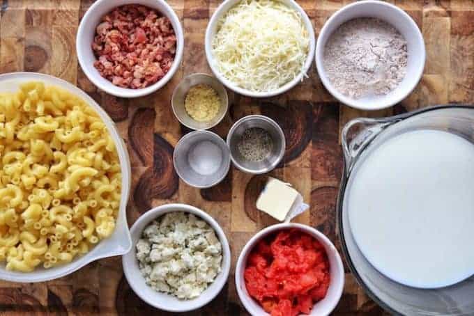 A bowl filled with different types of food on a table, with Cheese and Bacon