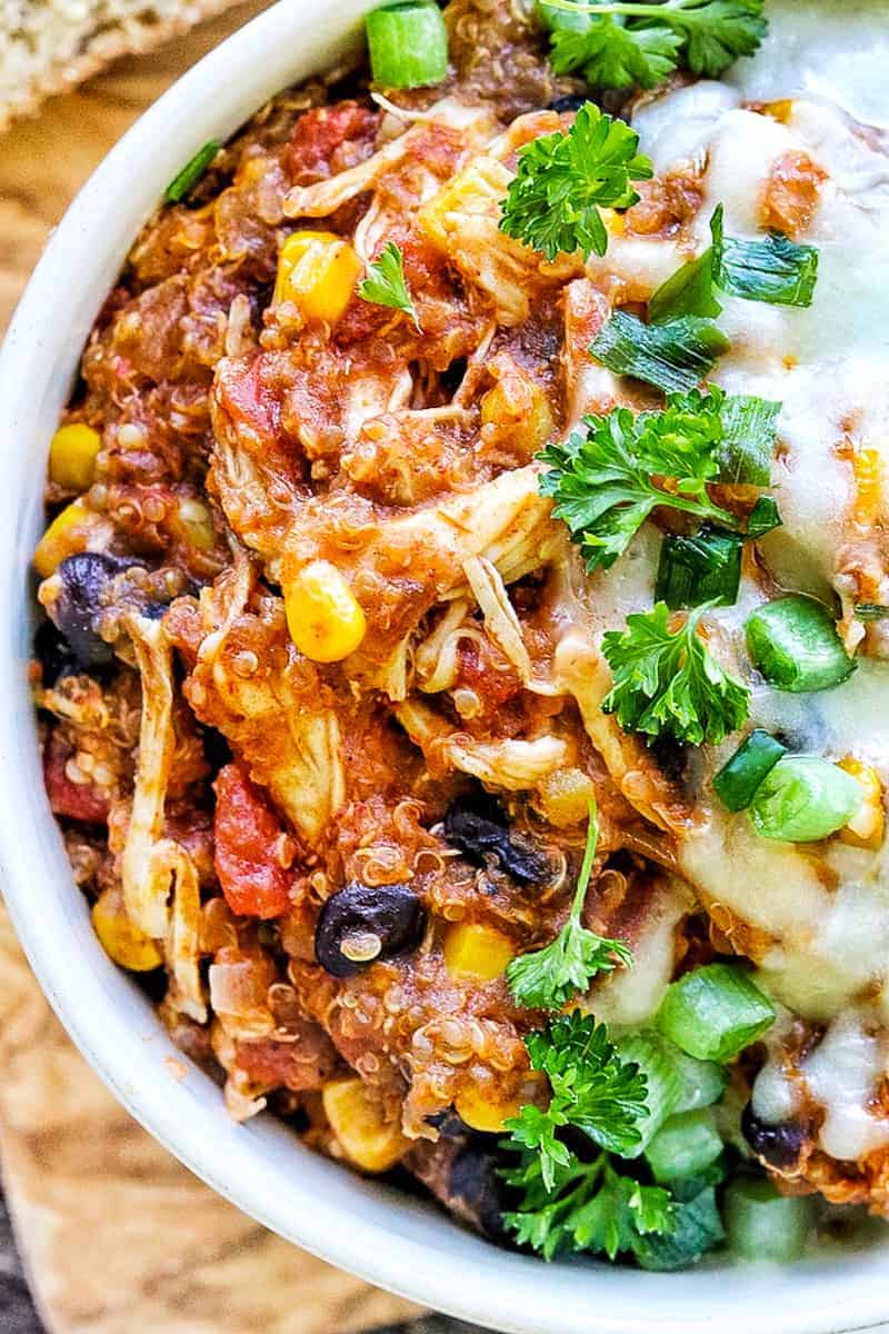 a close up of chicken, quinoa, black beans and corn in a casserole served in a bowl.