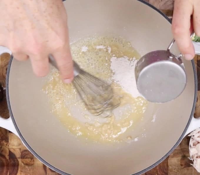 小麦粉を溶かしバターに入れて、白い鍋に簡単にチキンポットパイを入れます。