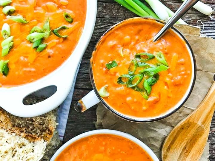 A bowl of soup and a spoon on a table, 