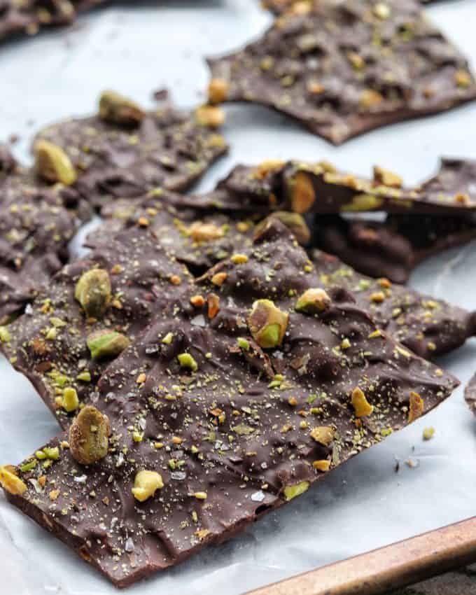 Chocolate bark recipe shown finished broken into peices showing a close up of the chocolate, sea salt, and pistachios. 
