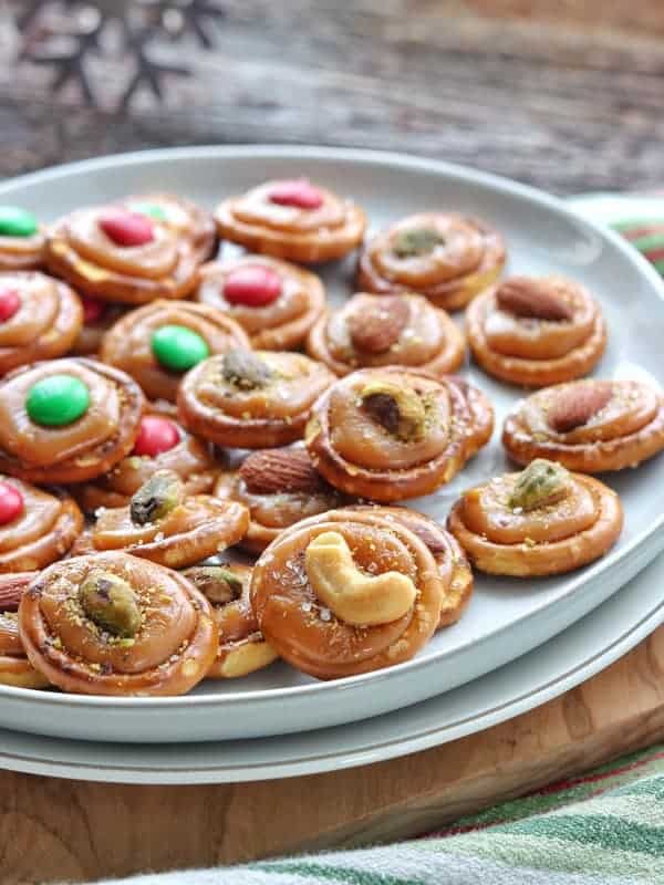 Christmas Pretzel Treats shown on a white plate with M&Ms and turtle pretzel treats.