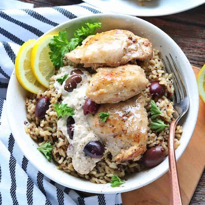 chicken thighs on top of wild rice with a cream sauce