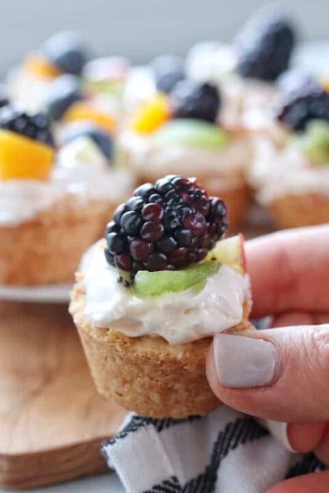 A close up of a fruit tart with a blackberry on top