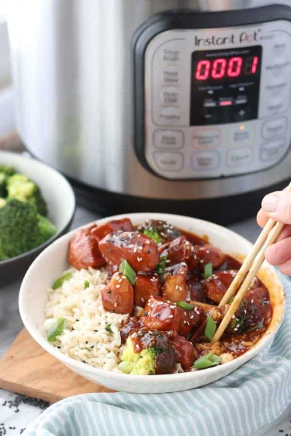 a bowl of Chinese chicken and rice with an instant pot in the background