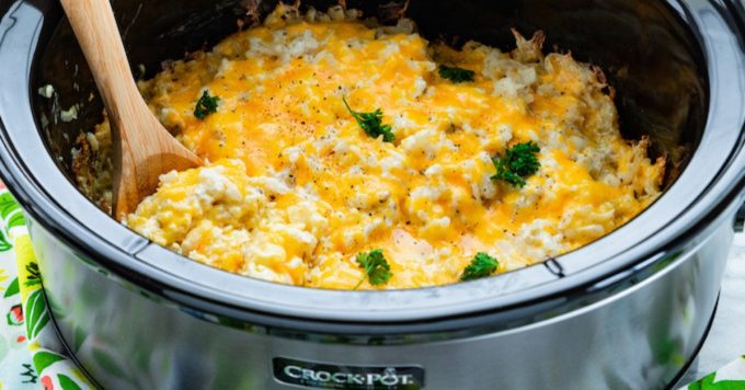 a crockpot filled with cheesy hashbrown potatoes baked