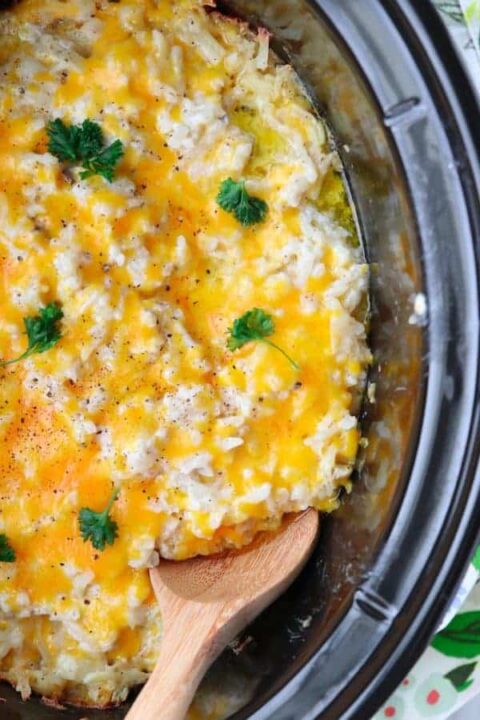 A close up of cheesy hashbrown potatoes in a crockpot