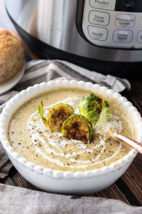 A bowl of soup sitting on a table with a spoon