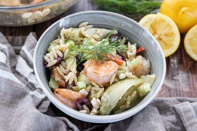 A bowl of food, with orzo and shrimpl