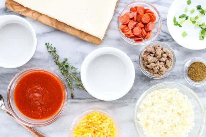 A bowl filled with different types of food on a table for pizza