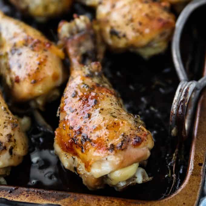 Crockpot chicken legs shown glistening with crispy skin on a pan.