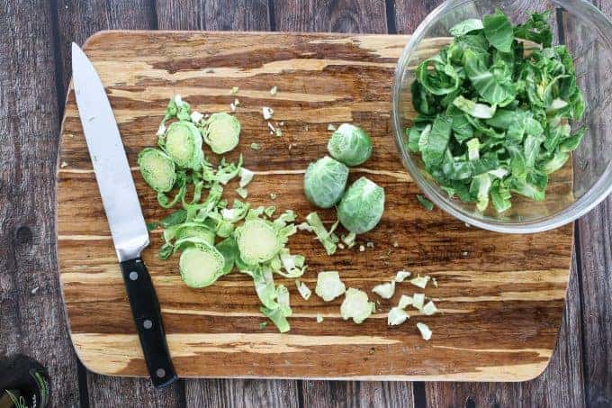 A wooden cutting board, with Sliced brussels sprouts