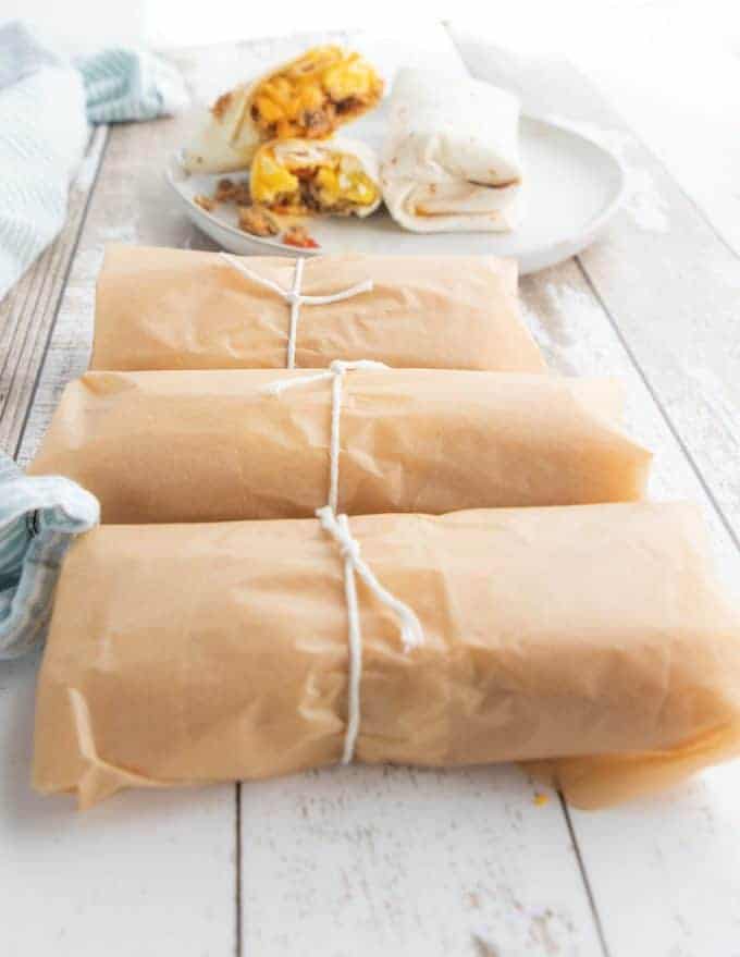 burritos wrapped in brown parchment paper tied with string