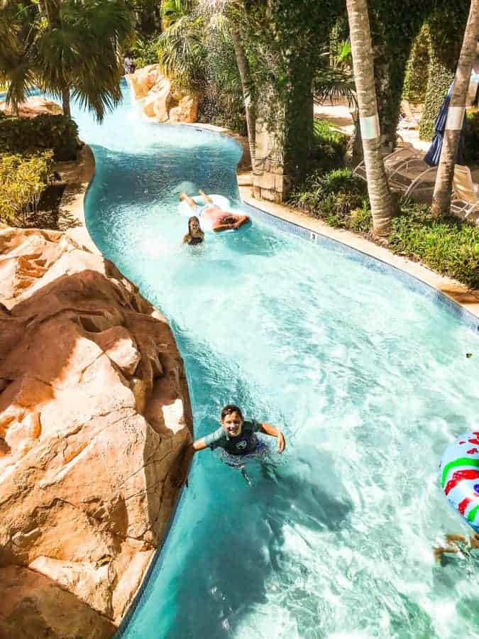 Hilton rose hall water park's lazy river with kids and adults floating on rafts