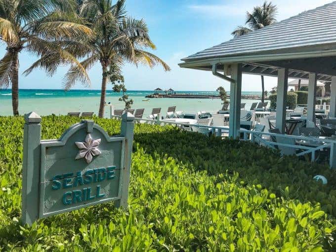 Seaside grill hilton rose hall showing the greenery outside the deck with the beach in the background.