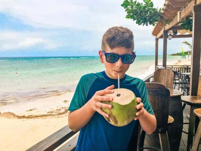 Hilton Rose Hall showing a boy drinking from a Coconut By the beach