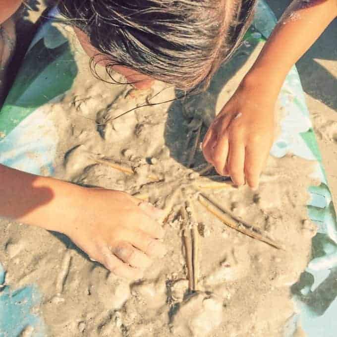 Girl uncovering a star fish on Sanibel Island Florida