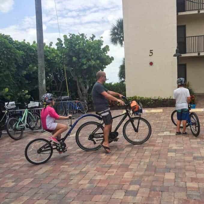 Dad with tandem bike with child in from of a hotel in Sanibel island Florida