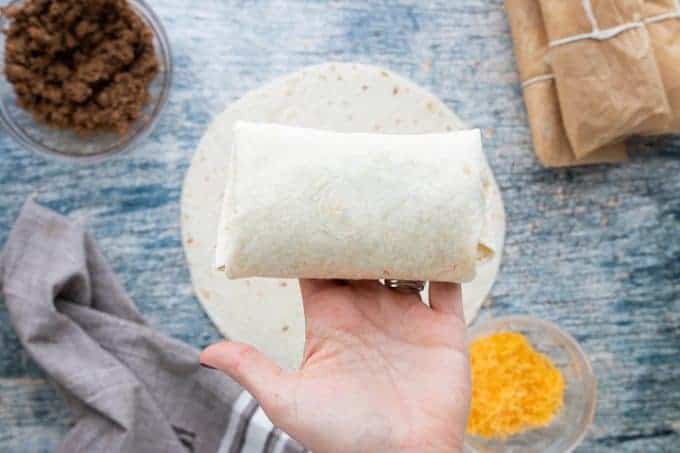 A person holding a burrito