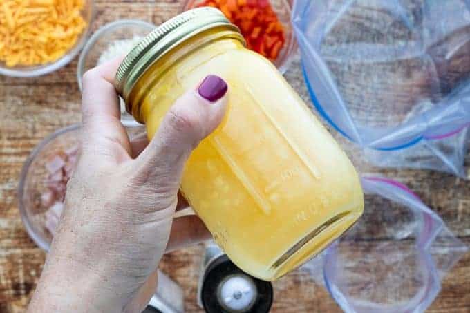 A person holding a mason jar with eggs