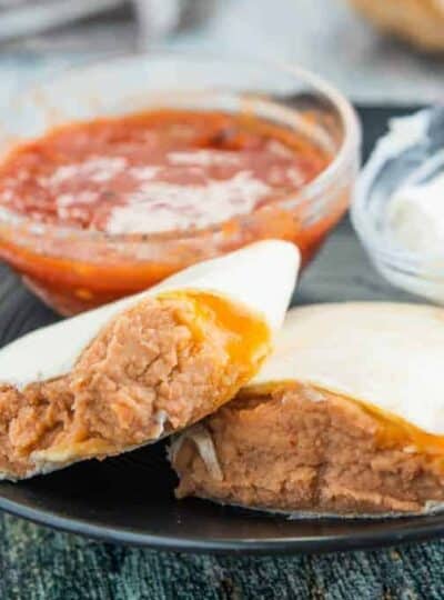 A tray of food on a plate, with Burrito and Refried beans