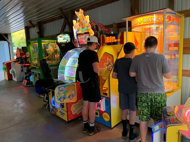 arcade at evergreen campground with 3 boys playing games.