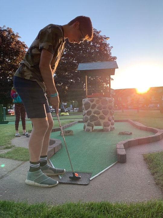 things to do in galena il showcasing a boy playing mini golf at sunset