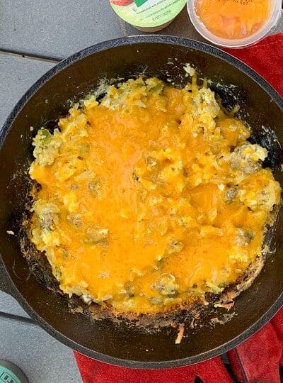 An egg Breakfast with cheese on top shown in a Cast Iron Skillet