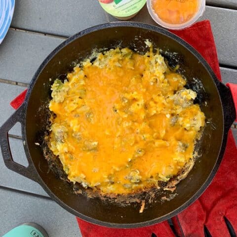 An egg Breakfast with cheese on top shown in a Cast Iron Skillet