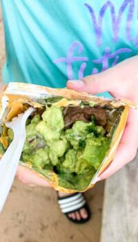 a girl holding a walking taco