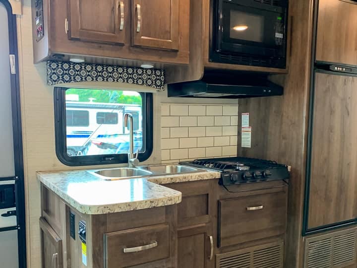 An RV kitchen with a stove and a microwave